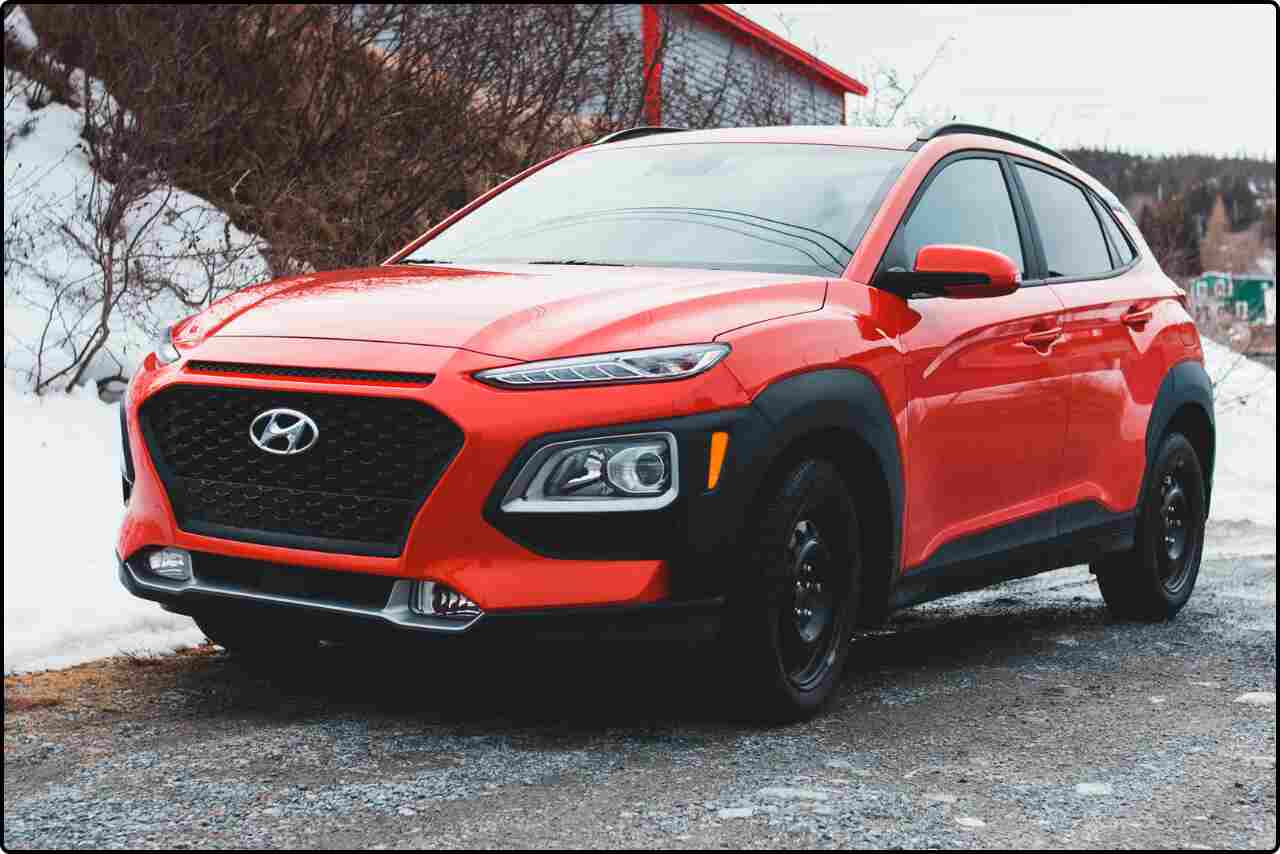 Red Hyundai car parked on a smooth gray concrete surface